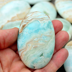 One blue caribbean calcite palm stone with background with some crystals