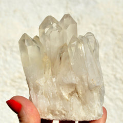 One large quartz crystal cluster on hand with white background