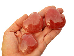 Trhee rose calcite heart crystals 45mm-50mm on hand with white background