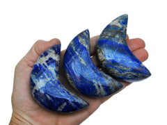 Three lapis lazuli moon crystals  70mm on hand with white background