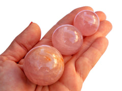 Some pink quartz crystal balls 25mm-40mm on hand with white background