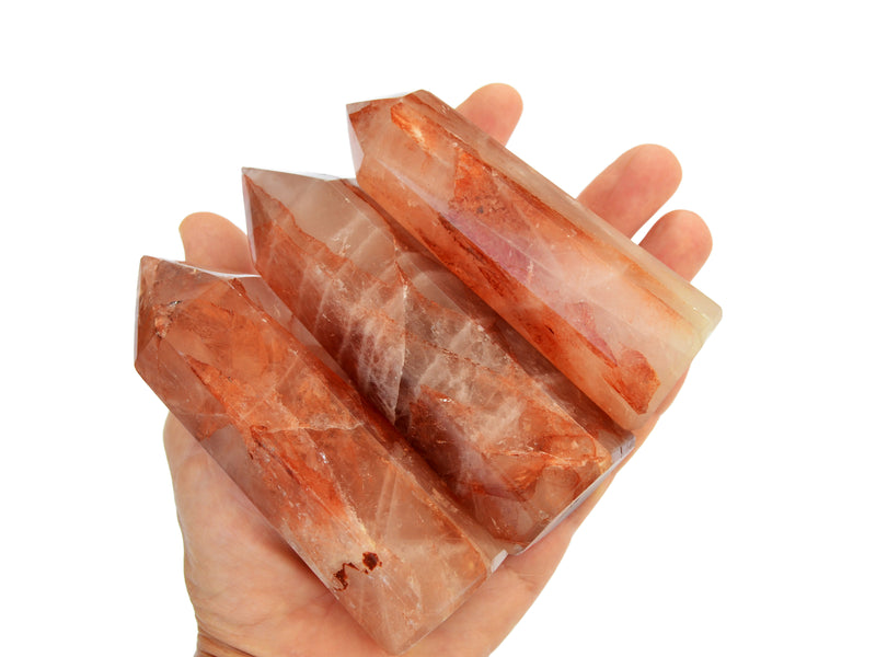 Fire quartz crystal towers 100mm on hand with white background