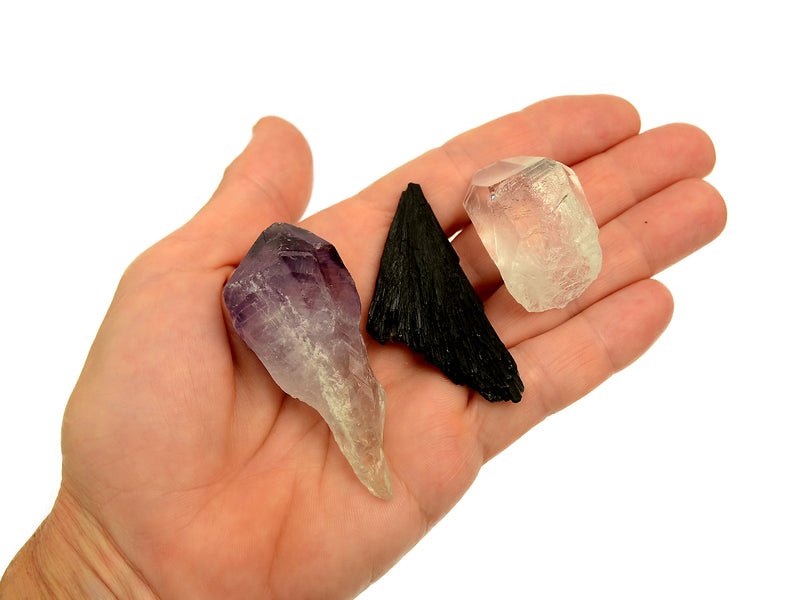 One raw amethyst point, raw black kyanite and clear quartz point 30mm-40mm on hand with white background