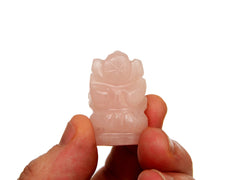 Reverse of mini pink quartz ganesha 35mm on hand with white background