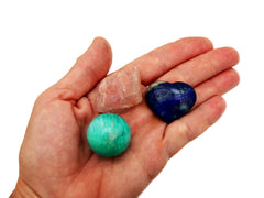 Raw rose quartz, green amazonite sphere and lapis lazuli heart 30mm on hand with white background