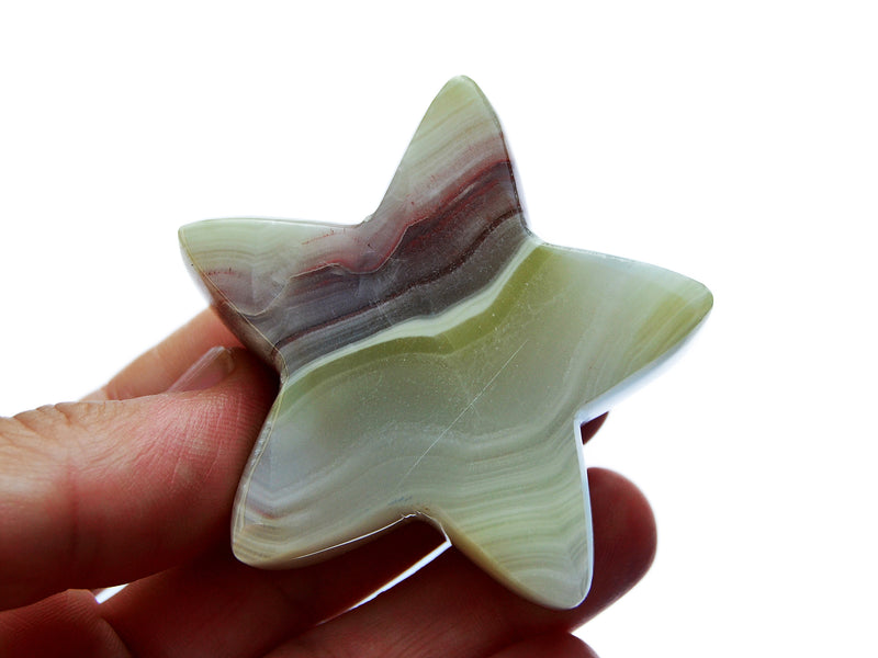 One pink banded onyx star carved mineral 60mm on hand with white background 