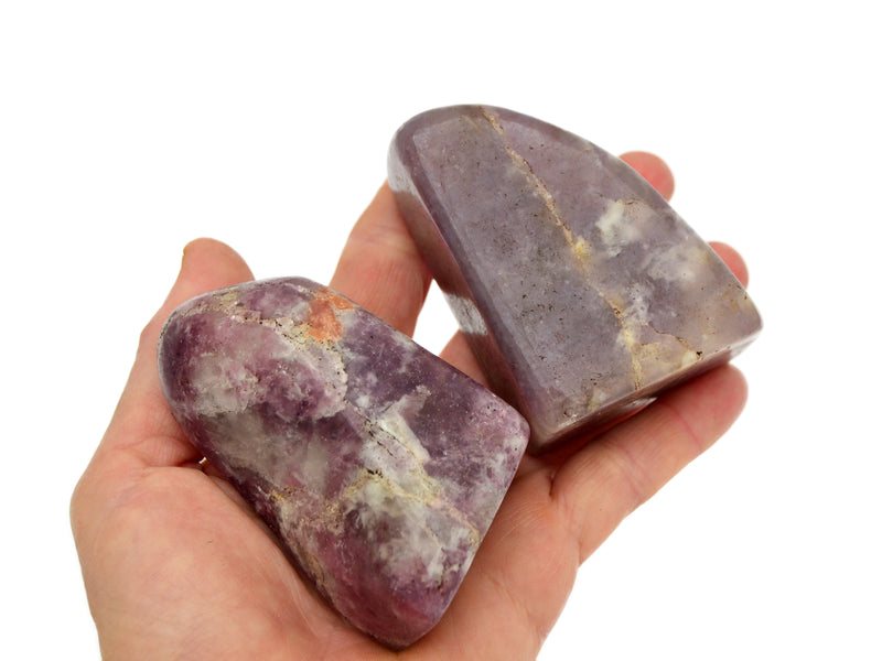 Two lepidolite free form crystals 70mm on hand with white background