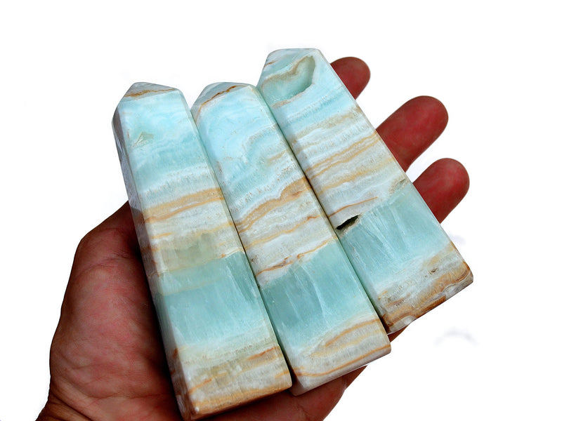 Three caribbean calcite towers 240mm on hand with white background