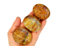 Three yellow hematoid quartz palmstones 55mm-60mm on hand with white background