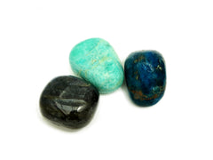One big labradorite, blue apatite and green amazonite tumbled stones on hand with white background