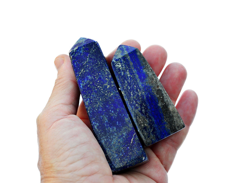 Two natural blue lapis lazuli crystal tower 60-80mm on hand with white background