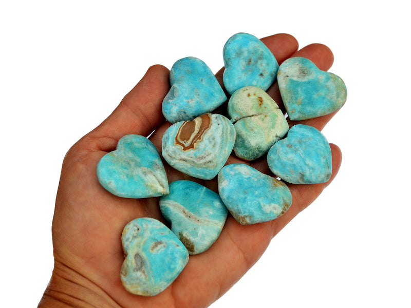 Ten blue aragonite hearts 30mm-35mm on hand with white background