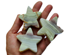 Three pink banded onyx star carving stones 55mm-60mm on hand with white background