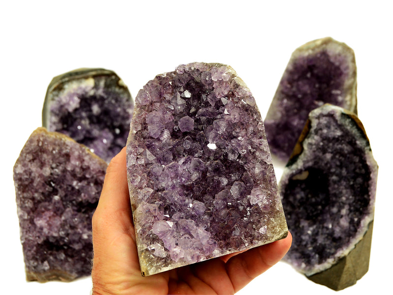 Natural druzy amethyst cut base 105mm on hand with background with some stones on white