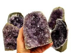 Natural druzy amethyst cut base 105mm on hand with background with some stones on white