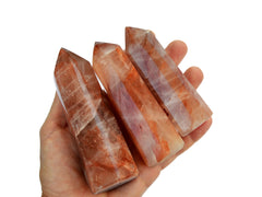 Three fire quartz towers 90mm on hand with white background