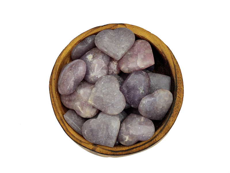 Lepidolite crystal hearts 25mm-45mm inside a wood bowl on white background