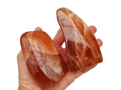 Two honey calcite free form minerals 90mm-110mm on hand with white background