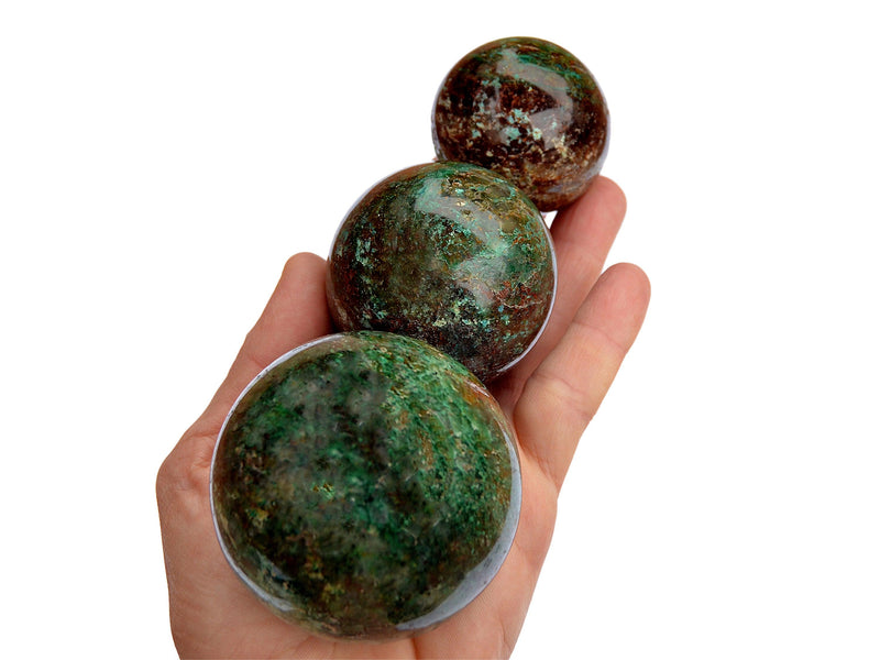 Three chrysocolla crystal spheres 40mm-65mm on hand with white background