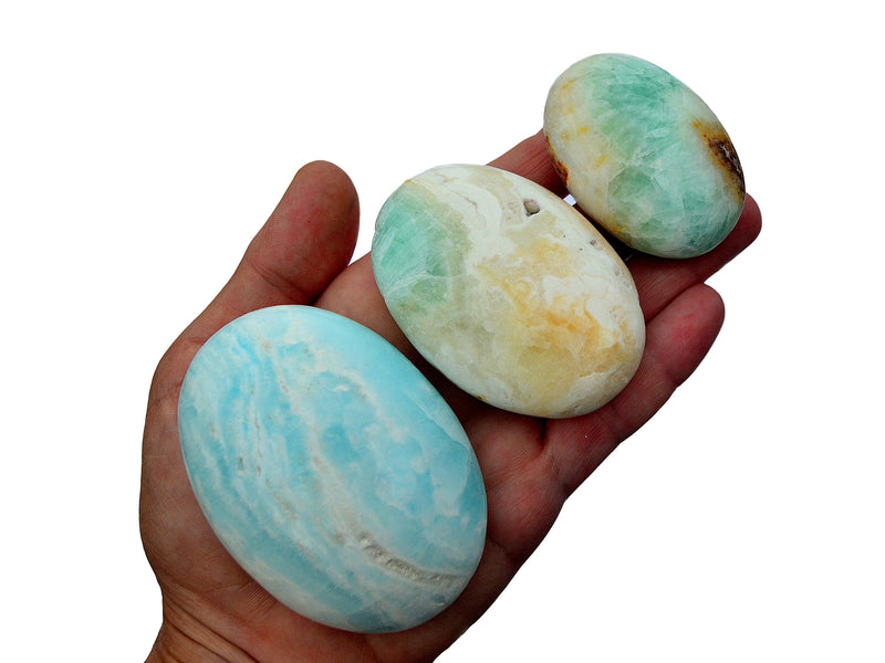 Three blue caribbean calcite palm stones 45mm-80mm on hand with white background