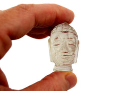 One mini clear quartz buddha head figure 40mm on hand with white background