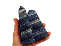 Two large lapis lazuli obelisks on hand with white background