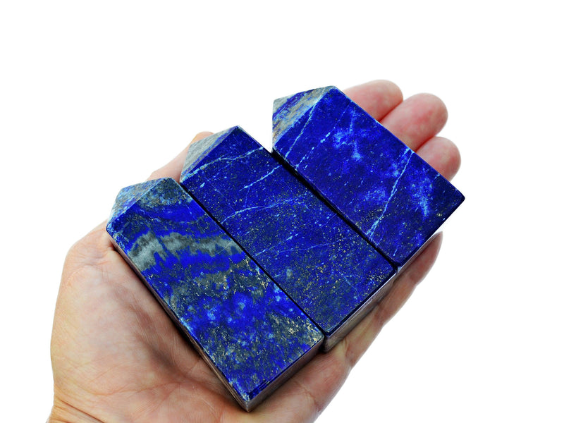 Three lapis lazuli tower stones 60mm-70mm on hand with white background
