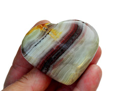 One pink banded onyx heart shapped crystal 50mm on hand with white background