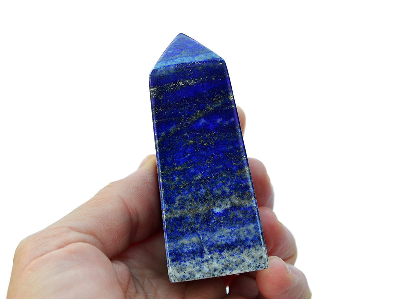 One natural blue lapis lazuli crystal tower 70mm  on hand with white background
