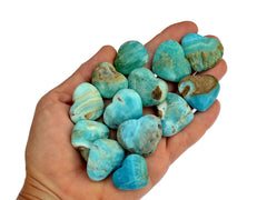Ten blue aragonite hearts 25mm-30mm on hand with white background