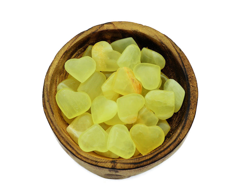 Several lemon calcite crystal hearts 25mm-30mm inside a wood bowl on white background