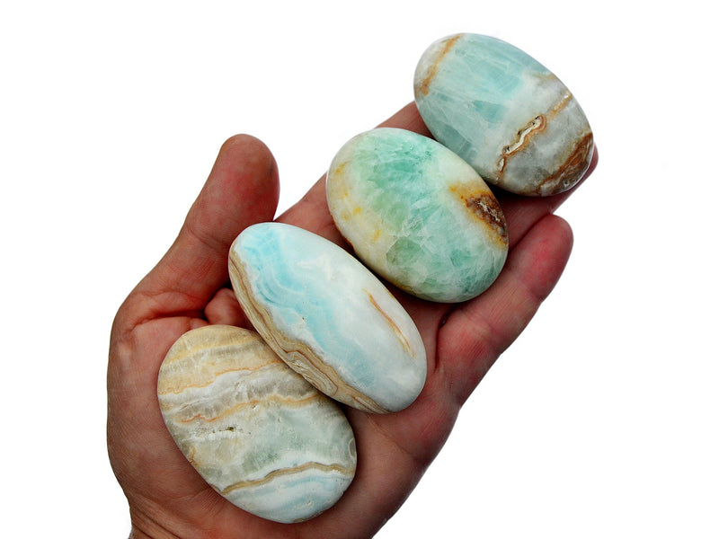 Four caribbean calcite palm stones 45mm-55mm on hand with white background