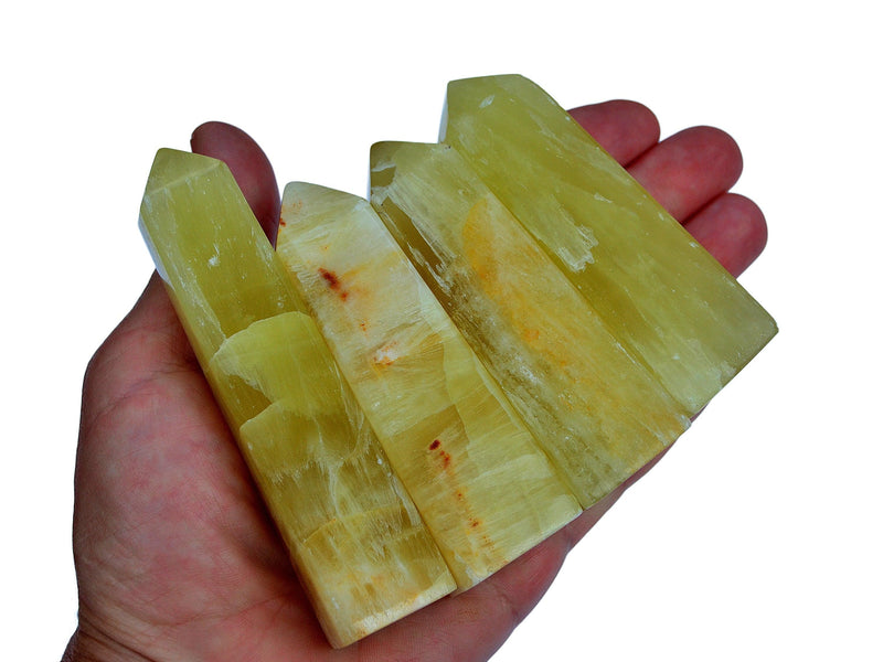 Four lemon calcite faceted crystal points 70mm-140mm on hand with white background
