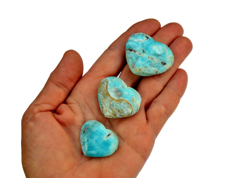 Three blue aragonite small heart crystals 25mm-40mm on hand with white background