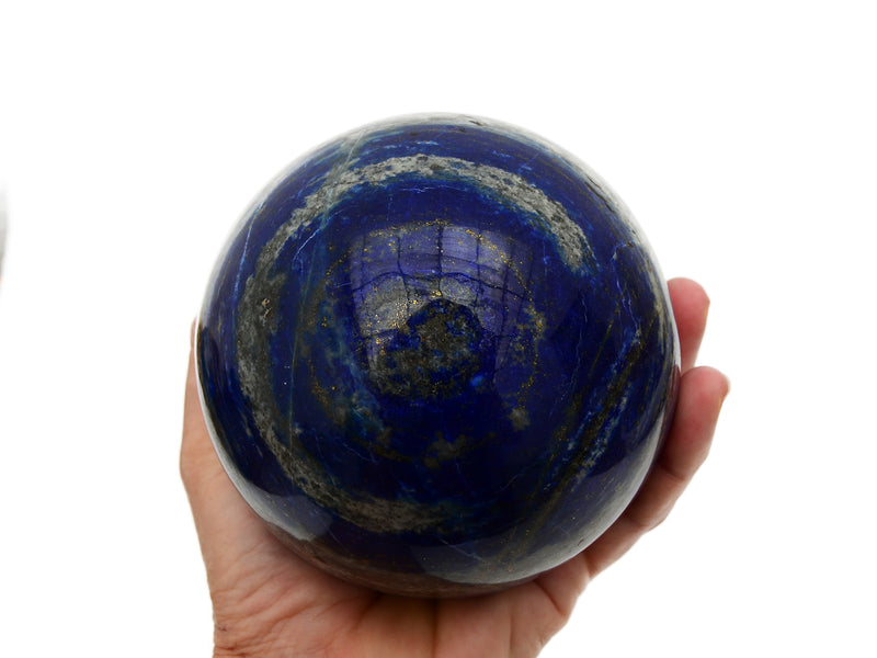 One lapis lazuli sphere stone 95mm on hand with white background