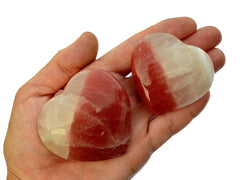 Rose calcite heart shapped minerals 60mm-65mm on hand with white background