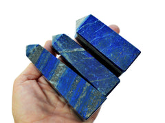 Three blue lapis lazuli crystal towers 60mm-90mm on hand with white background