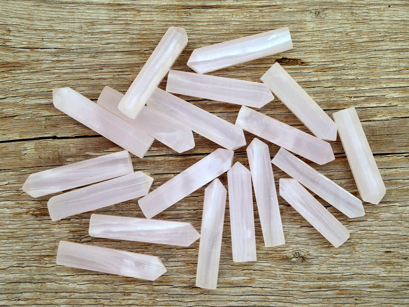 Several pink mangano calcite small crystal towers 55mm on wood table