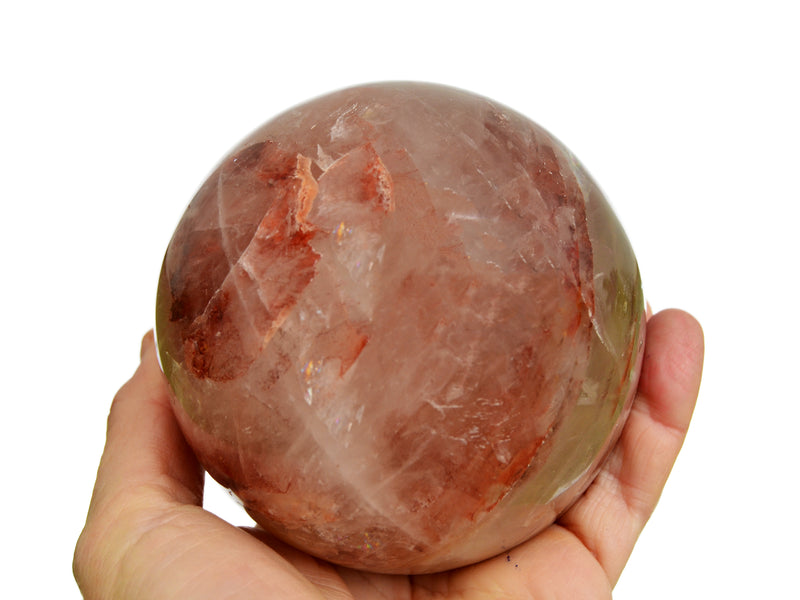 Big fire quartz sphere crystal 90mm on hand with white background