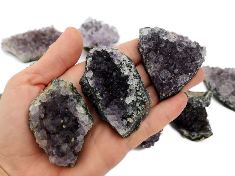 Three natural amethyst druzy crystals 50mm-70mm on hand with white background