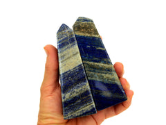 Two lapis lazuli obelisk stones 100mm on hand with white background