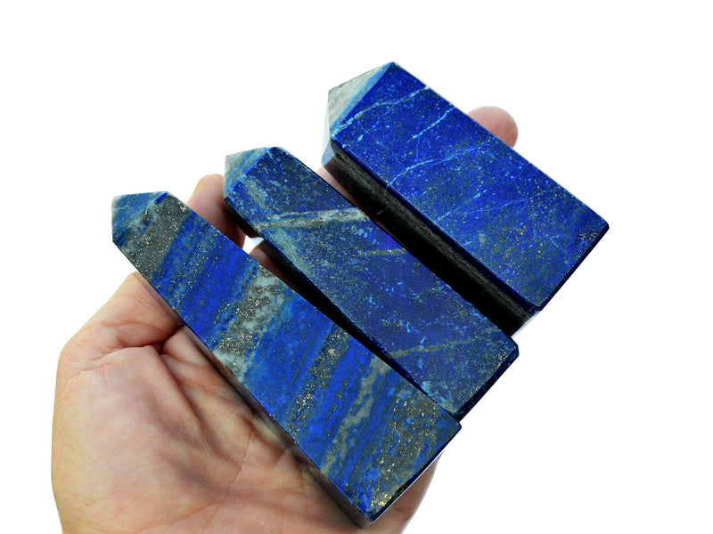 Three lapis lazuli tower stones 70mm-80mm on hand with white background
