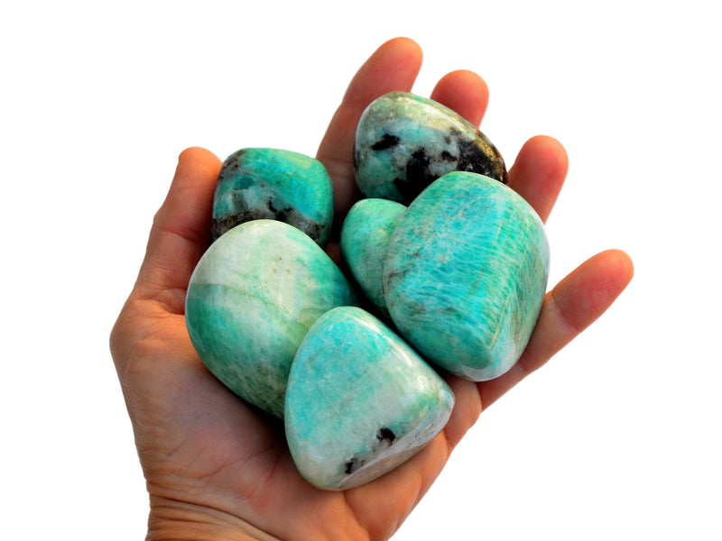 Six big green amazonite tumbled crystals on hand with white hackground