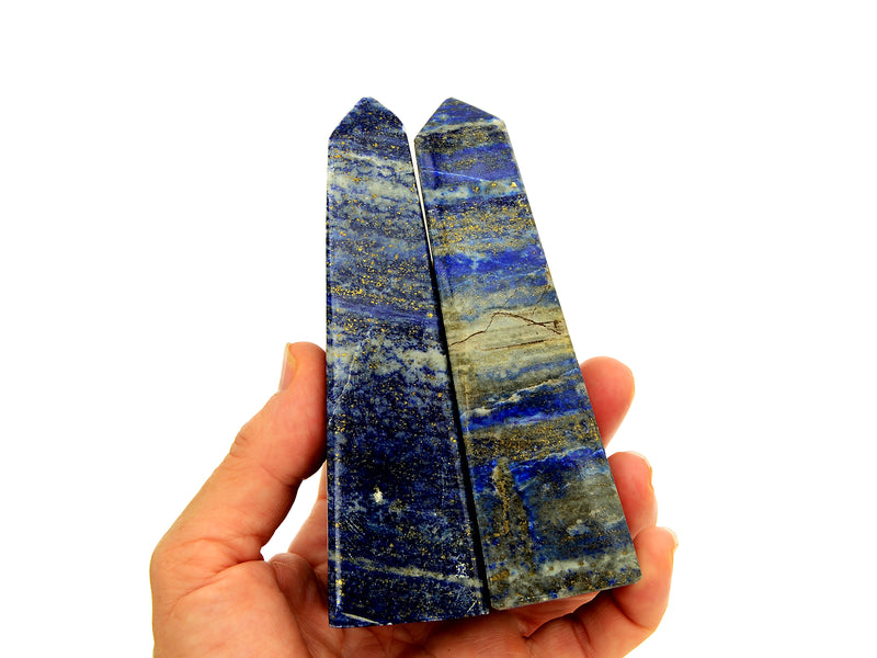 Two lapis lazuli obelisk stones 115mm on hand with white background