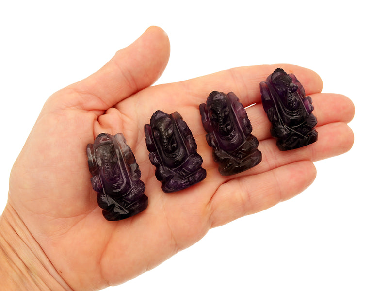 Four mini amethyst ganesha stone figures 35mm on hand with white background
