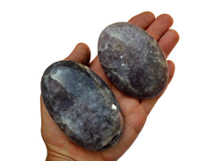 Two purple lepidolite palm stones 70mm-90mm on hand with white background