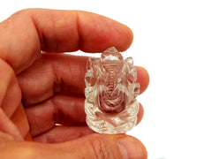 One mini clear quartz ganesha stone figure 35mm on hand with white background