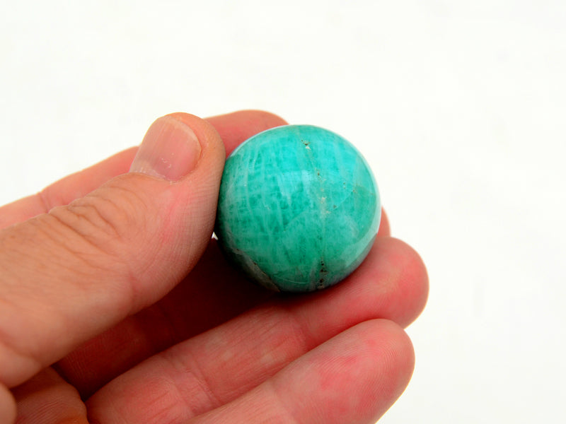 One green amazonite 30mm on hand with white background