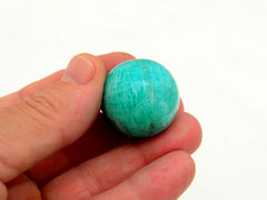 One green amazonite 30mm on hand with white background