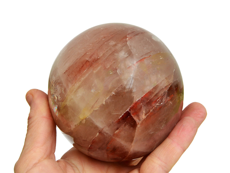 One big red hematoid quartz sphere 85mm on hand with white background